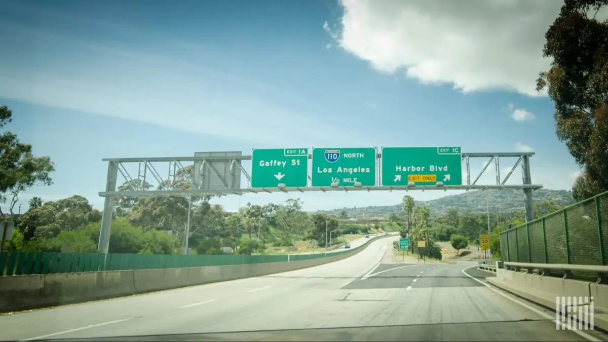 Freeway overpass with green highway signs directing to Gaffey St, Los Angeles, and Harbor Blvd; Exit 1A/1C with numbers and route 110 North 1/2 mile