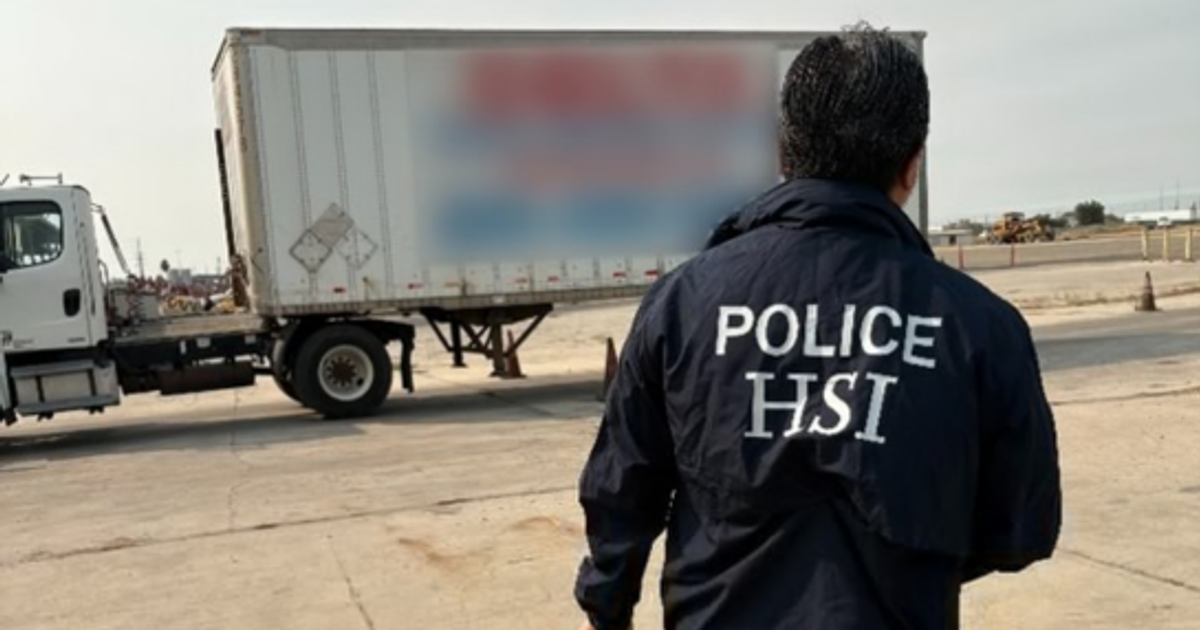 HSI officer beside a truck trailer