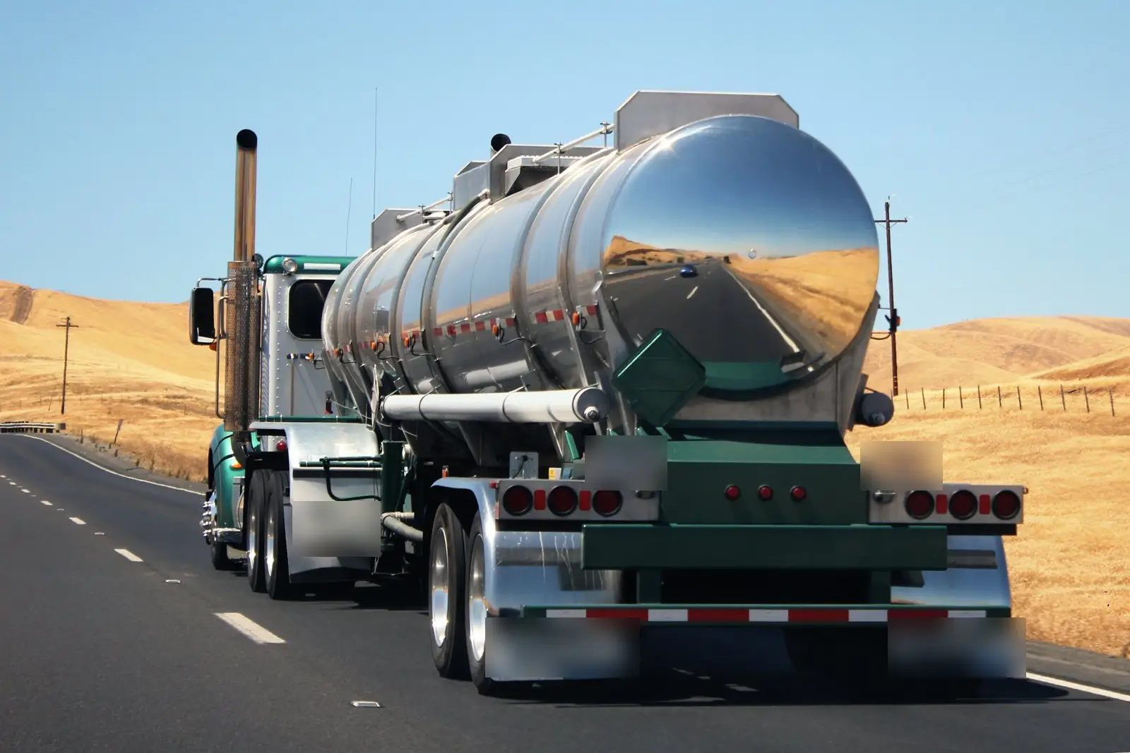 Tanker truck on a two-lane highway through dry hills